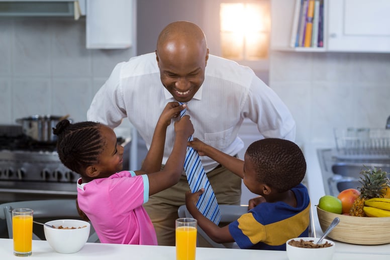 Children helping their father in tying tie at kitchen