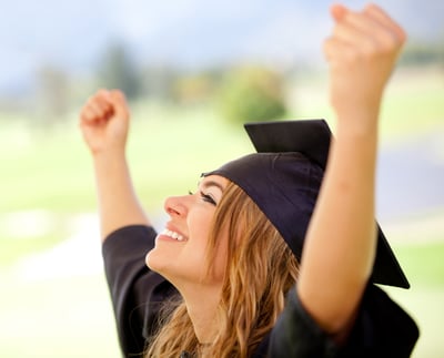 Female graduate with arms up succeeding in education