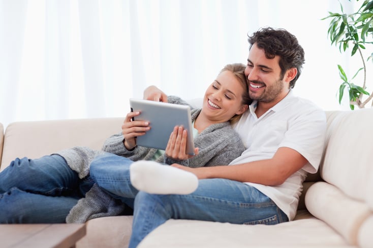 In love couple using a tablet computer in their living room