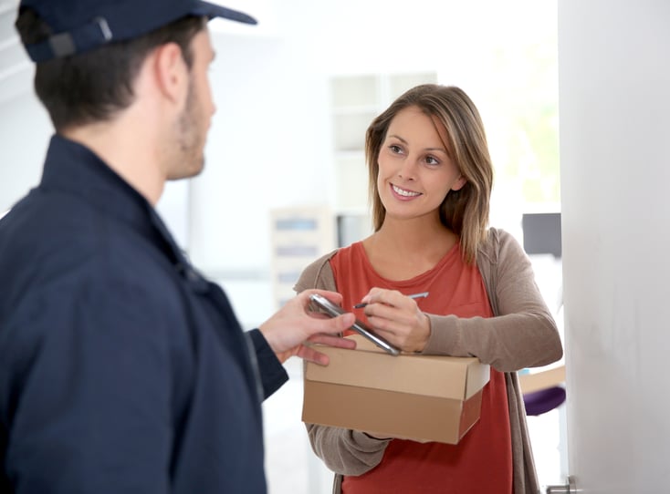Woman sigining electronic receipt of delivered package
