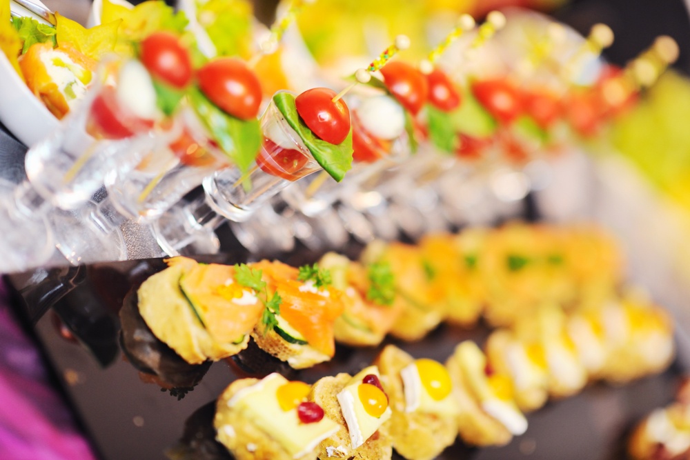 buffed food closeup of  fruits, vegetables, meat and fish arranged on banquet table